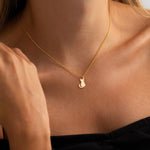 Gold-tone cat pendant necklace worn with a V-neck top