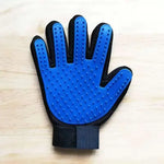 Blue cat grooming glove on a light wood surface