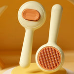 Yellow self-cleaning cat grooming brush