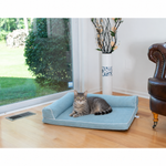 A tabby cat rests on the Blue Armarkat D08A pet bed beside a window