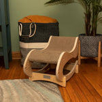 Armarkat wooden cat rocking chair beside a basket in a living room