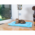 A tabby cat lounges on a Sky Blue Armarkat Large velvet mat beside a window