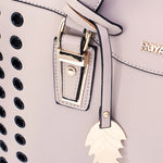 Close-up of the Aimee carrier’s faux leather finish, ventilation holes, stitching and gold-tone buckle
