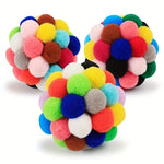 Close-up of colorful pom-pom cat toy balls on a white background