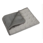 Light gray fabric cat resting mat with a folded corner showing the backing