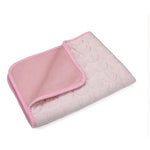 Pink fabric cat resting mat with a folded corner showing the backing