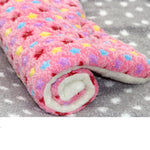 Pink star-patterned coral fleece cat resting mat with a rolled corner showing the white underside