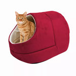 An orange tabby sits inside the Burgundy GOOPAWS covered cat cave bed
