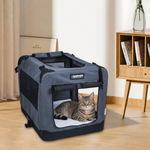 A cat rests in the Grey 26-inch JESPET soft crate beside a wooden cabinet