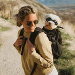 Outdoor family photograph showing the black Plus2 dog backpack in use