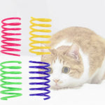 Colorful plastic spring cat toys beside a cat