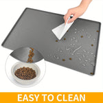 Hand wiping the gray raised-edge cat feeding mat, with an inset showing loose food being tipped into a bowl.